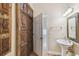 Unique half bath featuring carved wood door, terracotta tile flooring, and decorative mirror at 2508 W Shell Point Rd, Tampa, FL 33611