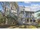 Rear exterior of the home featuring a deck, pergola and mature trees at 2508 W Shell Point Rd, Tampa, FL 33611