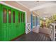 Charming covered front porch featuring a vibrant green double door entrance at 2508 W Shell Point Rd, Tampa, FL 33611