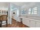 Bright kitchen area featuring a built-in desk area, white cabinetry, and terracotta tile floors at 2508 W Shell Point Rd, Tampa, FL 33611