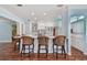 Open concept kitchen with terracotta tile floors, a bar and seating, white cabinets and modern appliances at 2508 W Shell Point Rd, Tampa, FL 33611
