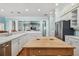 Kitchen boasts white cabinets, stainless appliances, and an island with breakfast bar with seamless flow to living area at 2508 W Shell Point Rd, Tampa, FL 33611