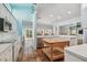 Open kitchen featuring terracotta tile floors, white cabinets, stainless appliances, and an island with breakfast bar at 2508 W Shell Point Rd, Tampa, FL 33611