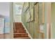 Staircase with terracotta tile steps, wood plank art, and chandelier, leading to additional living space at 2508 W Shell Point Rd, Tampa, FL 33611
