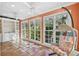 Bright sun room featuring terracotta tile floors, built-in shelving, and a hanging chair next to three large windows at 2508 W Shell Point Rd, Tampa, FL 33611