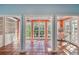 Open view of the bright sun room featuring terracotta tile floors, built-in shelving, and large picture windows at 2508 W Shell Point Rd, Tampa, FL 33611