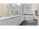 Bathroom featuring double sinks, a large mirror, and a soaking tub at 2717 Via Cipriani # 620A, Clearwater, FL 33764