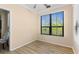 Bedroom with light walls and wood-look floors with a large window offering a view at 2717 Via Cipriani # 620A, Clearwater, FL 33764