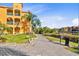 Exterior view of a condo building with a brick walkway and a view of the water and palm trees at 2717 Via Cipriani # 620A, Clearwater, FL 33764