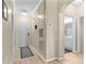 Hallway with neutral walls, light wood floors, white doors, a decorative mask, and an open bathroom at 2717 Via Cipriani # 620A, Clearwater, FL 33764