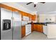 Well-lit kitchen featuring stainless steel refrigerator, white appliances, wood cabinets, and granite counters at 2717 Via Cipriani # 620A, Clearwater, FL 33764