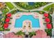 Aerial view of a large community pool surrounded by cabanas, chairs, and lush landscaping at 2717 Via Cipriani # 620A, Clearwater, FL 33764