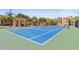 Well-maintained blue and green outdoor tennis court with net in a fenced in area at 2717 Via Cipriani # 620A, Clearwater, FL 33764