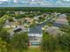 An aerial view of the house showing a screened-in pool and lush landscaping in a neighborhood at 3000 Sunwatch, Wesley Chapel, FL 33544