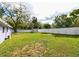 Large, grassy backyard featuring a privacy fence and mature trees at 3302 W Van Buren Dr, Tampa, FL 33611