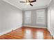 Empty bedroom featuring warm hardwood floors, neutral paint, a ceiling fan, and bright natural light at 5807 N Branch Ave, Tampa, FL 33604