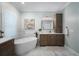 Bright bathroom featuring a soaking tub, marble floors, a vanity and large framed mirror at 6411 Grenada Island Ave, Apollo Beach, FL 33572