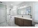This bathroom features a glass enclosed shower, modern fixtures and marble floors at 6411 Grenada Island Ave, Apollo Beach, FL 33572