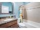 Cozy bathroom with granite vanity, shower-tub combo, and tiled wall accent at 6411 Grenada Island Ave, Apollo Beach, FL 33572