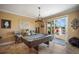 Billiards room with a pool table, bar stools, a decorative chandelier, and sliding doors leading to an outdoor area at 6411 Grenada Island Ave, Apollo Beach, FL 33572