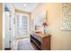 Elegant entryway with a decorative console table, artwork, and a front door with glass panels allowing natural light at 6411 Grenada Island Ave, Apollo Beach, FL 33572