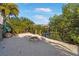 Sandy backyard with a brick fire pit, foliage, and views of the canal and neighboring homes at 6411 Grenada Island Ave, Apollo Beach, FL 33572