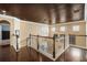 Spacious upper hallway with hardwood floors, detailed railing, and natural light at 6411 Grenada Island Ave, Apollo Beach, FL 33572