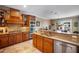 Stylish kitchen featuring wooden cabinets, granite countertops, stainless steel appliances, and a connecting dining area at 6411 Grenada Island Ave, Apollo Beach, FL 33572