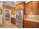 Well-equipped kitchen with stainless steel appliances, wooden cabinetry, a pantry, and tile backsplash at 6411 Grenada Island Ave, Apollo Beach, FL 33572