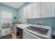 Functional laundry room with modern washer, dryer, cabinetry, and sink at 6411 Grenada Island Ave, Apollo Beach, FL 33572