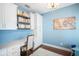 Bright office with custom built-ins, stylish light fixture, and beautiful blue accent wall at 6411 Grenada Island Ave, Apollo Beach, FL 33572