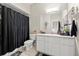 Bathroom featuring a large vanity, shower with a dark curtain, decorative elements and tile flooring at 6980 Ulmerton Rd # 8C, Largo, FL 33771