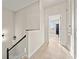 Upstairs hallway featuring wood floors, stairwell with black accents, and natural light at 6980 Ulmerton Rd # 8C, Largo, FL 33771