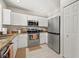 Well-equipped kitchen featuring white cabinets, stainless appliances, and wood look flooring at 6980 Ulmerton Rd # 8C, Largo, FL 33771