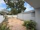 Backyard featuring a stone patio, mature trees, storage shed, and privacy fence at 8503 N Willow Ave, Tampa, FL 33604