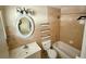 Traditional bathroom with tub, toilet and vanity, neutral colors and tiled walls at 8503 N Willow Ave, Tampa, FL 33604