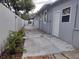 Side exterior view of home with white fence, showing walkway and building features at 8503 N Willow Ave, Tampa, FL 33604