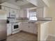 Bright kitchen with white cabinets and countertop seating at 8503 N Willow Ave, Tampa, FL 33604