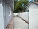 Long side yard between two fences with partial brick and partial concrete paver flooring at 8503 N Willow Ave, Tampa, FL 33604