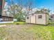 A spacious backyard featuring a storage shed, open patio, and green space at 10608 Sassafras St, Tampa, FL 33617