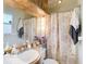 This bathroom has a single sink vanity, floral shower curtain, and neutral walls at 10608 Sassafras St, Tampa, FL 33617