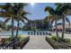 Community pool area with lounge chairs surrounded by mature palm trees at 1227 Queen Anne Dr # C, Palm Harbor, FL 34684