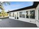 Exterior of home featuring large windows, a gray deck, and water views at 1514 Sea Gull S Dr, St Petersburg, FL 33707