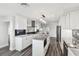 Well-lit kitchen with white cabinets, granite countertops, stainless appliances, and luxury vinyl flooring at 1514 Sea Gull S Dr, St Petersburg, FL 33707
