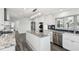 Bright kitchen showcasing white cabinets, granite counters, stainless appliances, and luxury vinyl plank flooring at 1514 Sea Gull S Dr, St Petersburg, FL 33707