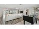 Open-concept living room with plank floors, foosball table, and water views to dining room at 1514 Sea Gull S Dr, St Petersburg, FL 33707