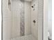 Modern shower with neutral-toned mosaic tile accent and pebbled floor in a glass-enclosed space at 1514 Sea Gull S Dr, St Petersburg, FL 33707