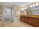 Bathroom featuring double sink vanity with granite countertops and large mirror with lighting at 19429 Paddock View Dr, Tampa, FL 33647