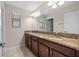 Bathroom showcasing double sinks, granite countertops, vanity, and large mirror with lighting at 19429 Paddock View Dr, Tampa, FL 33647