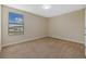 Bedroom featuring neutral walls, plush carpeting, and a window overlooking a home at 19429 Paddock View Dr, Tampa, FL 33647